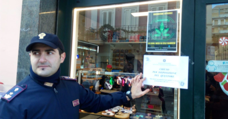 Un poliziotto davanti a una tabaccheria che era stata chiusa per la vendita di cannabis light in provincia di Macerata. (ANSA)