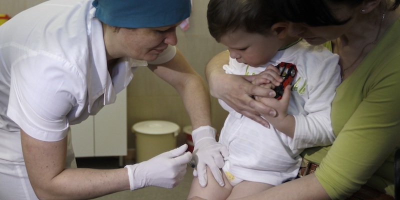 Un'infermiera vaccina un bambino a Kiev, in Ucraina, il 23 aprile 2013 (AP Photo/Sergei Chuzavkov)