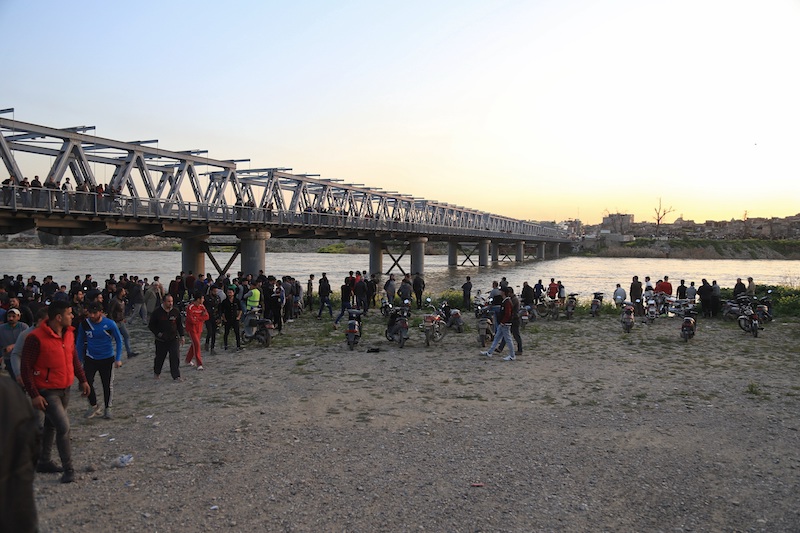 Un gruppo di persone sulle sponde del fiume Tigri, dove è affondato il traghetto (AP Photo/Farid Abdulwahed)