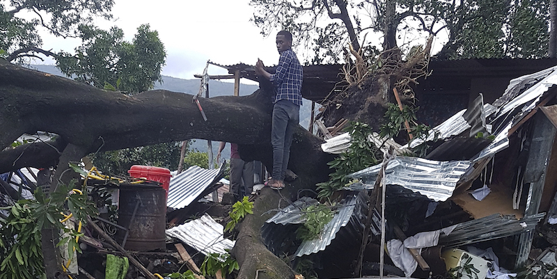 Un uomo in piedi sopra un albero che ha distrutto la sua casa a Moroni, nelle isole Comore, dove il ciclone Kenneth è passato prima di dirigersi in Mozambico. (AP PhotoAnziza M'Changama)
