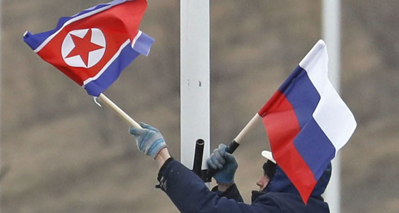 Un operaio sistema due bandiere, una russa e una della Corea del Nord, lungo la strada che porta a 
Vladivostok, in vista del summit tra Kim Jong-un e Vladimir Putin. (Kyodo via AP Images)