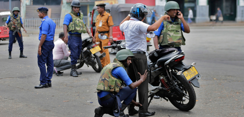 Un poliziotto perquisisce un motociclista a Colombo, dopo gli attentati di Pasqua. (AP Photo/Eranga Jayawardena)