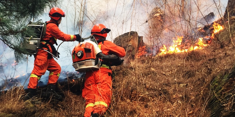 Vigili del fuoco cinesi al lavoro per spegnere un incendio nelle montagne del Sichuan, il 20 marzo 2019 (Imaginechina via AP Images)