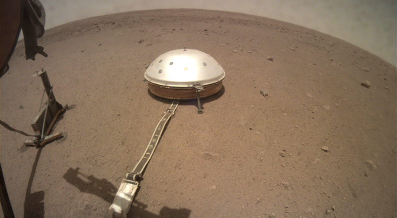 Il sismografo nel suo involucro protettivo sul suolo di Marte (NASA)