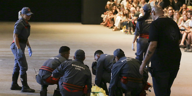 Un gruppo di soccorritori intorno al modello Tales Soares su una passerella della settimana della moda di San Paolo, in Brasile, il 27 aprile 2019 (Leco Viana/Thenews2 via AP)