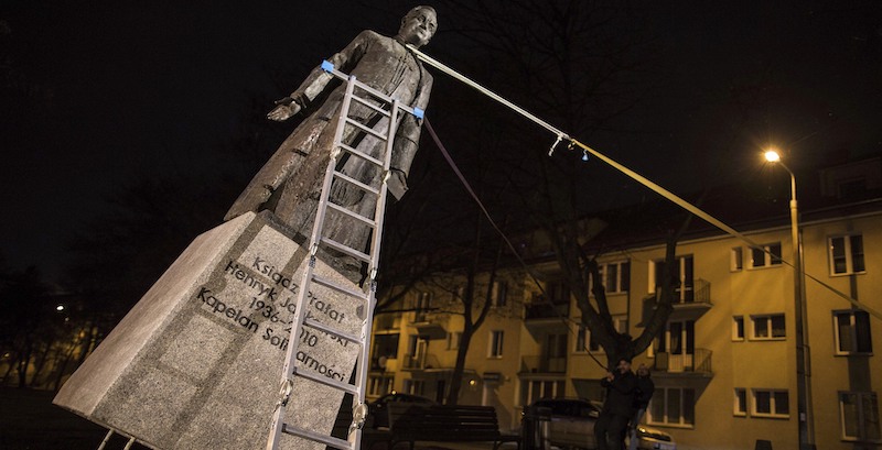 Alcuni attivisti tirano giù la statua di don Henryk Jankowski, sacerdote membro del movimento Solidarność, accusato di avere abusato di minori a Danzica. (AP Photo/Bartek Sabela/Gazeta Wyborcza)