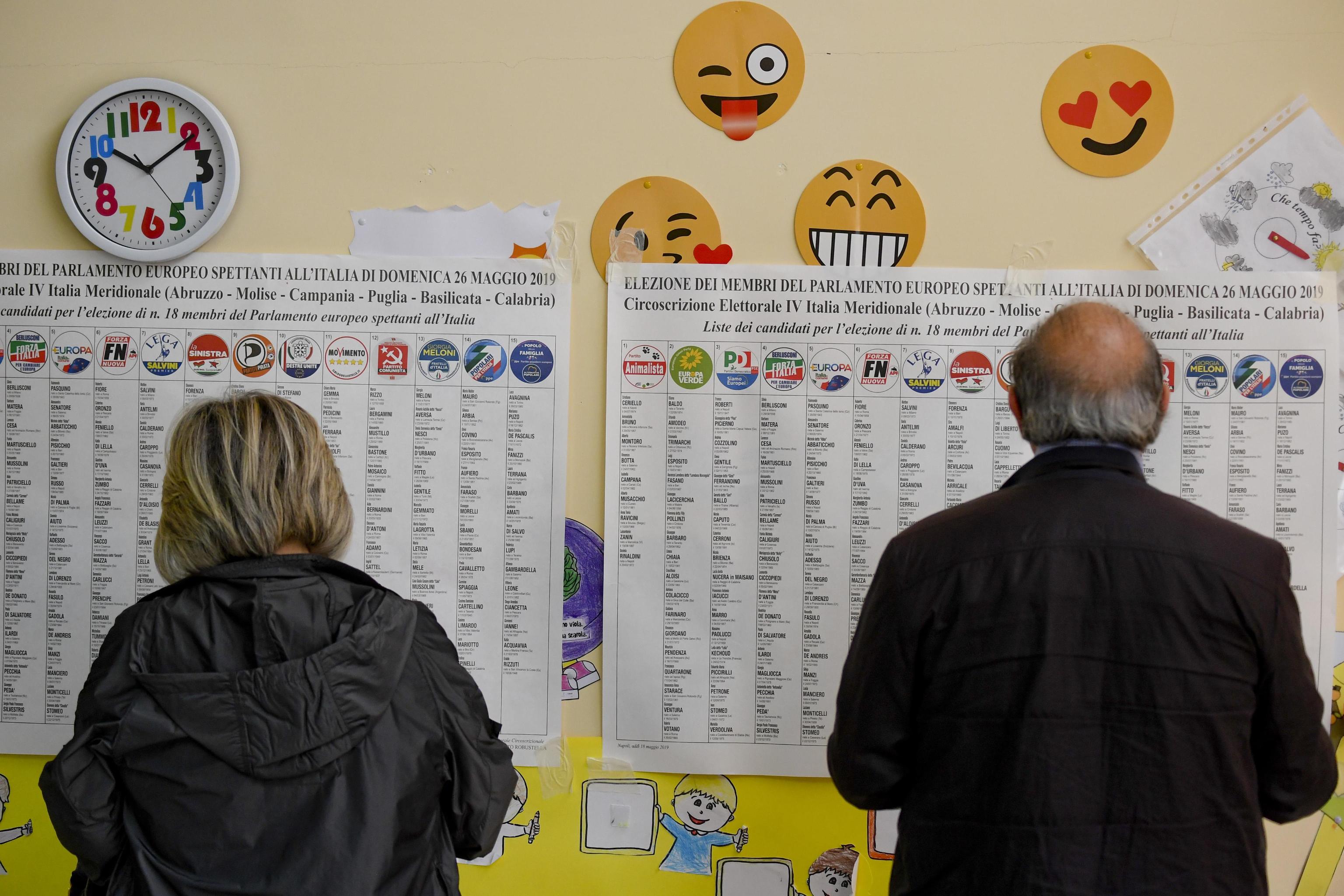 Una donna e un uomo osservano i simboli in un seggio nel giorno delle elezioni europee, Pomigliano D'Arco (Napoli). (ANSA / CIRO FUSCO)
