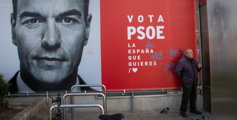 Un uomo davanti a un cartellone elettorale del PSOE. (Pablo Blazquez Dominguez/Getty Images)