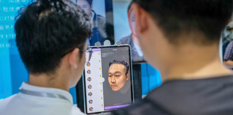 Un visitatore di un evento tecnologico di Pechino mentre prova il riconoscimento facciale di un'intelligenza artificiale (Imaginechina via AP Images)