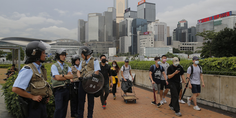 Alcuni poliziotti in tenuta antisommossa e un gruppo di manifestanti contro l'emendamento sull'estradizione vicino alla sede del Consiglio legislativo di Hong Kong, il 13 giugno 2019 (AP Photo/Kin Cheung)