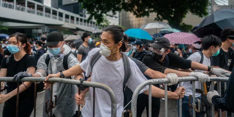 Manifestanti contrari all'emendamento alla legge sull'estradizione di Hong Kong spostano transenne per bloccare una strada vicino agli edifici governativi della città, il 12 giugno 2019 (Anthony Kwan/Getty Images)