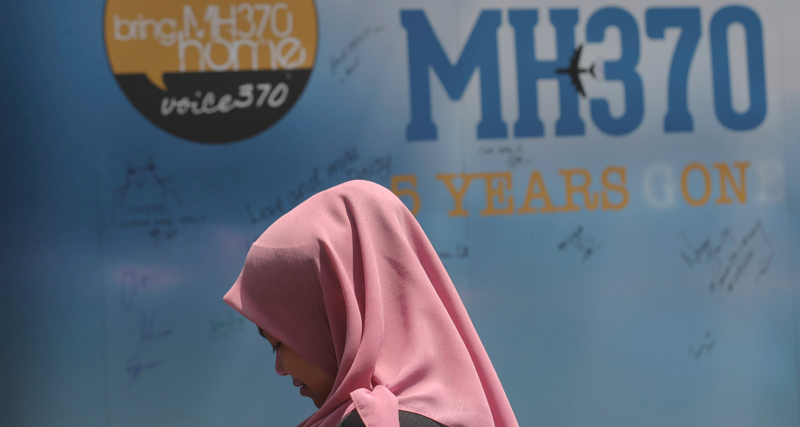 Una ragazza davanti a un cartellone in ricordo delle vittime del volo MH370 a Kuala Lumpur. (AP Photo/Vincent Thian)