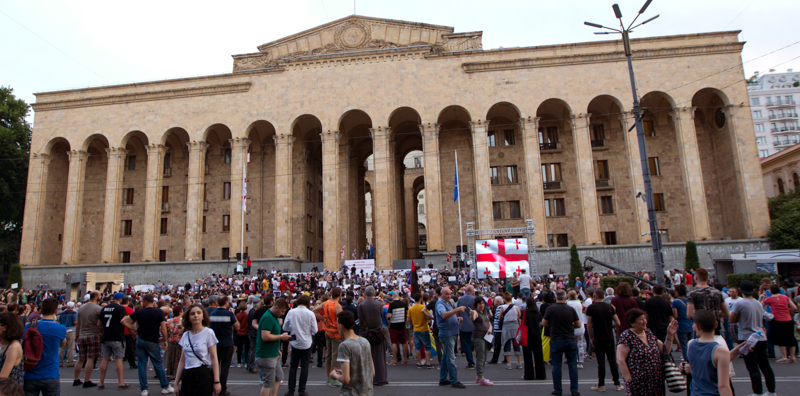 Alcuni manifestanti davanti al Parlamento georgiano nella giornata di domenica. (AP Photo/Shakh Aivazov)