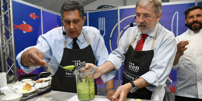 Il presidente della regione Liguria Giovanni Toti (a sinistra) e il sindaco di Genova Marco Bucci mentre preparano un piatto di acciughe per una manifestazione culinaria (ANSA/LUCA ZENNARO)