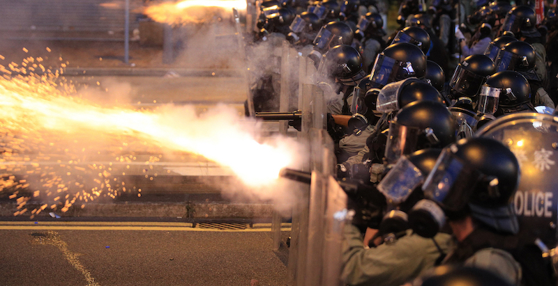 Poliziotti sparano gas lacriogeni contro i manifestanti a Sai Wan, Hong Kong, domenica 28 luglio (Jeff Cheng/HK01 via AP)