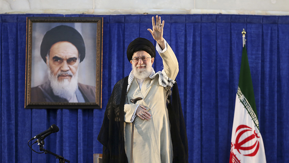 Ali Khamenei, Guida suprema dell'Iran, con alle spalle una foto di Ruhollah Khomeini, leader della Rivoluzione del 1979 (Office of the Iranian Supreme Leader via AP)