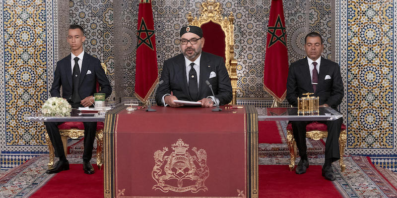 Il re del Marocco Mohammed VI, al centro, tiene un discorso per i suoi vent'anni di regno nel palazzo reale di Tétouan; alla sua destra c'è suo figlio e principe ereditario Hassan, dall'altra parte invece suo fratello Rashid (Palazzo Reale del Marocco via AP)
