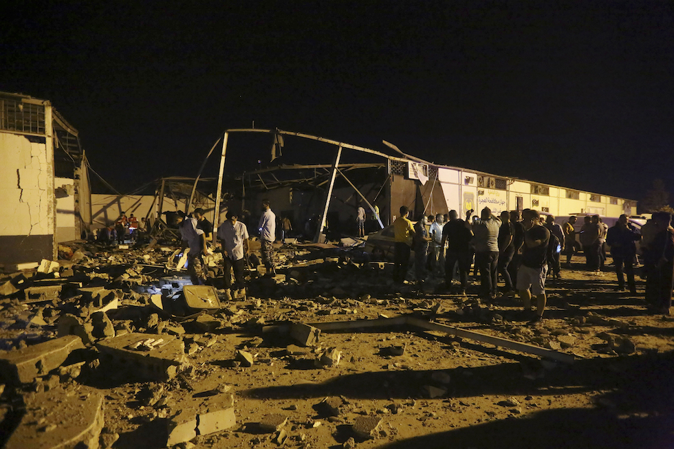 Soccorritori intorno al centro di detenzione per migranti di Tajoura, colpito nell'attacco (AP Photo/Hazem Ahmed)