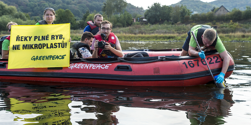 Attivisti di Greenpeace raccolgono campioni d'acqua nell'Elba, in Repubblica Ceca, per verificare la presenza di microplastiche, il 6 settembre 2018 (Ondrej Hajek/CTK via AP Images)