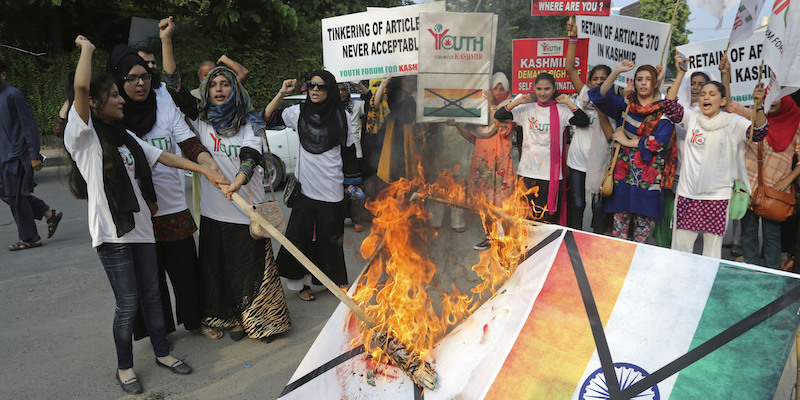 Studentesse pakistane bruciano un poster con la faccia del primo ministro indiano Narendra Modi e la bandiera dell'India per protestare contro la revoca dell'autonomia del Kashmir, a Lahore, il 7 agosto 2019 (AP Photo/K.M. Chaudary)