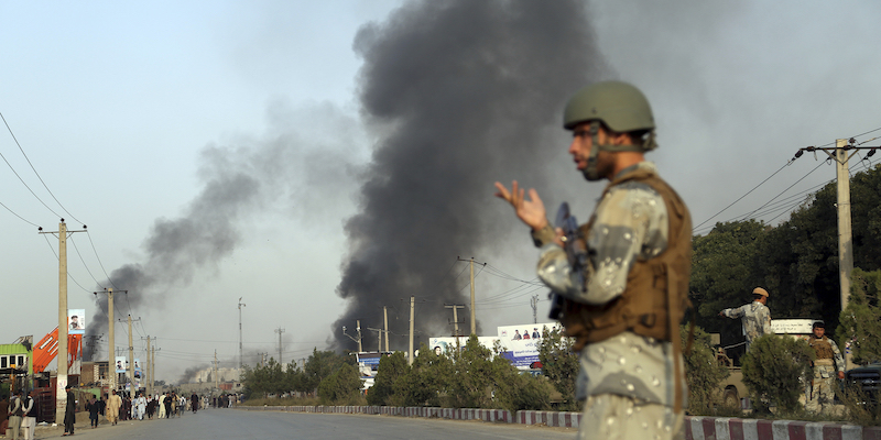 Un poliziotto afghano davanti alla colonna di fumo causata dall'esplosione di un'autobomba a Kabul, il 3 settembre 2019 (AP Photo/Rahmat Gul)