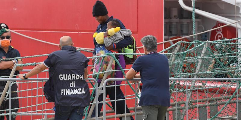 Una migrante con un bambino in braccio sbarca dalla Ocean Viking a Messina, il 24 settembre 2019 (ANSA/CARMELO IMBESI)