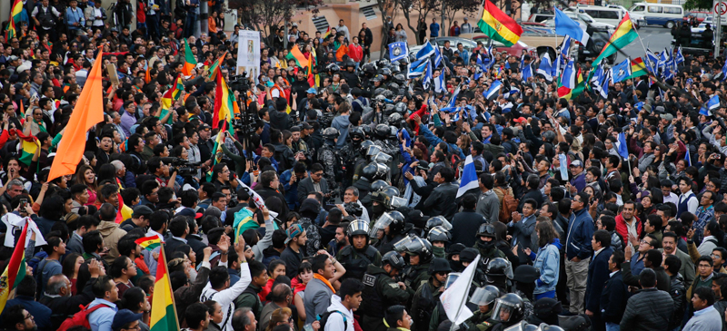 Un cordone di polizia separa i sostenitori del presidente boliviano uscente Evo Morales da quelli del suo sfidante Carlos Mesa. (Jorge Saenz/Getty Images)