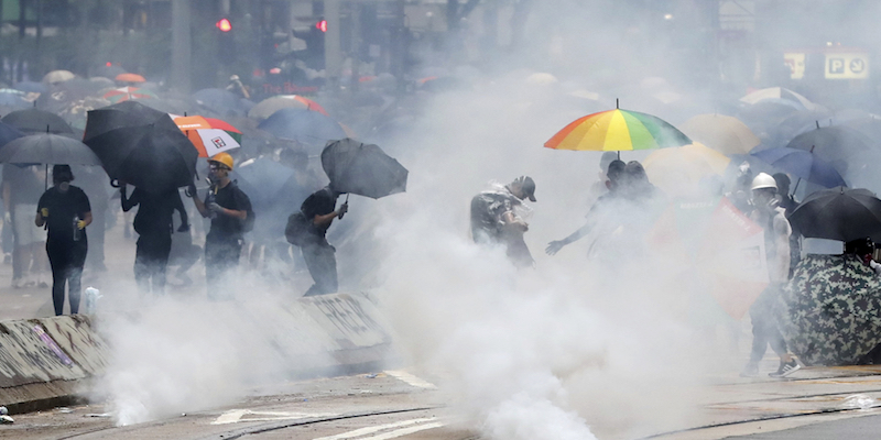 Manifestanti in mezzo al gas lacrimogeno, a Hong Kong, il 6 ottobre 2019 (The Yomiuri Shimbun via AP Images )