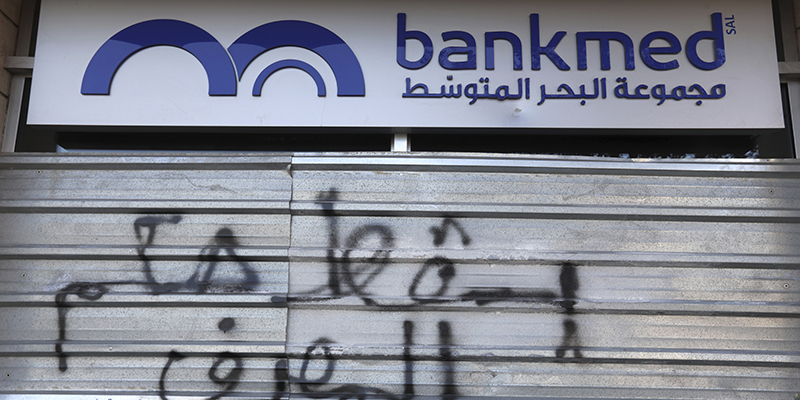 La serranda abbassata di una banca con la scritta "Abbasso il dominio delle banche", Beirut, 12 novembre 2019 (AP Photo/Hassan Ammar)