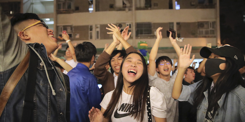 Alcune persone pro-democrazia festeggiano dopo la vittoria del proprio candidato nelle elezioni locali di Hong Kong (AP Photo/Kin Cheung)
