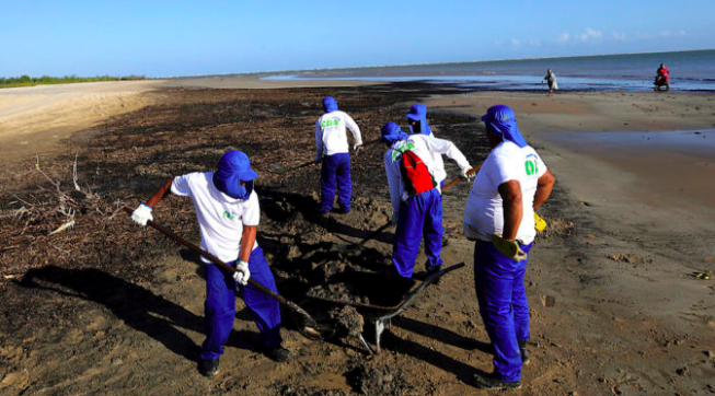Operatori al lavoro per bonificare una spiaggia contaminata dal petrolio vicino ad Aracaju, nello stato del Sergipe, Brasile – 8 ottobre 2019 (Andre Moreira/Aracaju Municipal Press Office via AP)