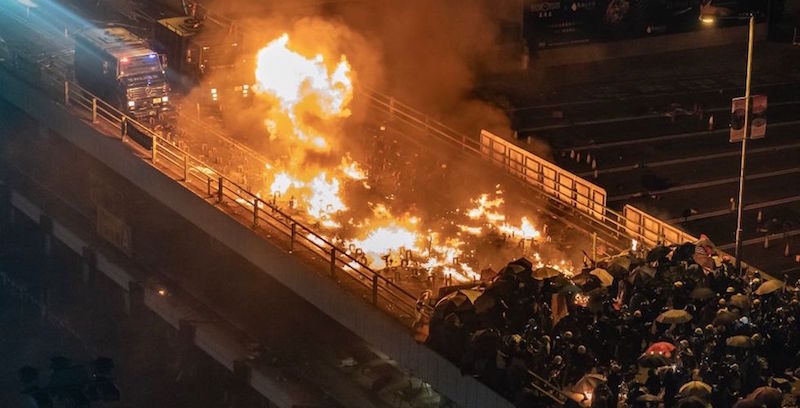 Un incendio su uno dei ponti che portano verso il Politecnico di Hong Kong, domenica 17 novembre (Anthony Kwan/Getty Images)