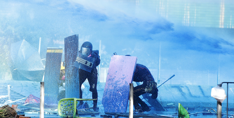 Manifestanti colpiti da un liquido blu lanciato dalla polizia durante gli scontri al Politecnico di Hong Kong, 17 novembre 2019
(AP Photo/Achmad Ibrahim)