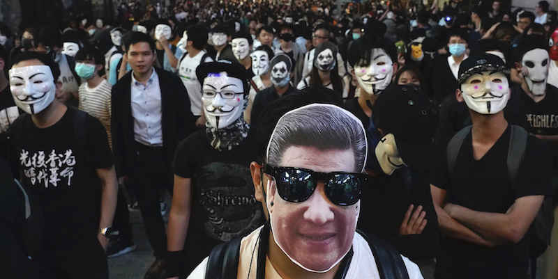 Un uomo con la maschera del presidente cinese Xi Jinping (AP Photo/Vincent Yu)