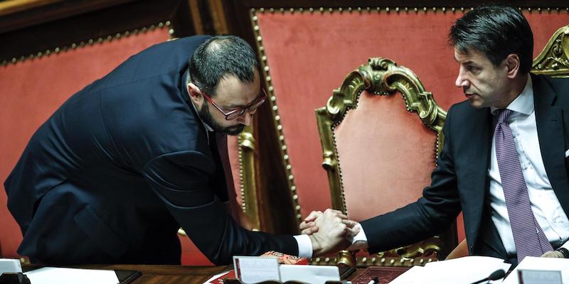 Il ministro dello Sviluppo economico Stefano Patuanelli e il presidente del Consiglio Giuseppe Conte in Senato durante le dichiarazioni di voto, l'11 dicembre 2019 (ANSA/GIUSEPPE LAMI)