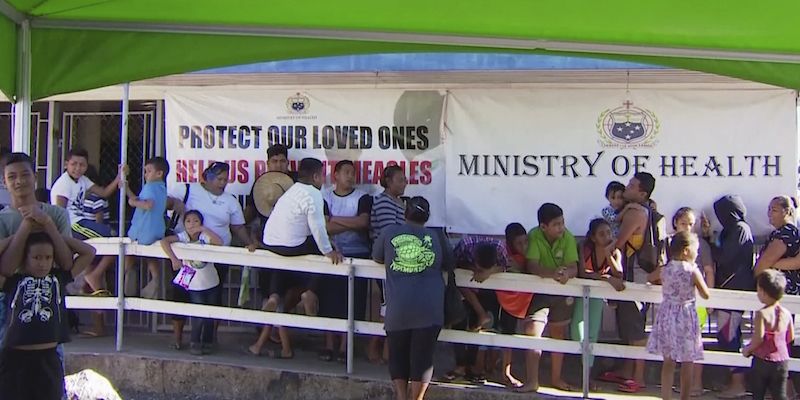 Adulti e bambini in coda per ottenere il vaccino per il morbillo all'esterno di una clinica ad Apia, Samoa (TVNZ via AP)