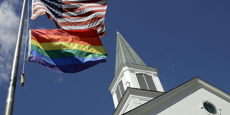 Una bandiera arcobaleno e una americana issate fuori dalla chiesa metodista di Prairie Village, in Kansas, il 19 aprile 2019 (AP Photo/Charlie Riedel)
