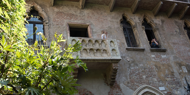 Una coppia di turisti e il balcone della cosiddetta "casa di Giulietta", a Verona (LaPresse -Emanuele Pennacchio)