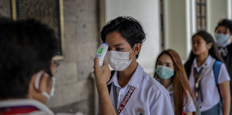 Studenti si fanno misurare la temperatura corporea prima di entrare in un'università a Manila, nelle Filippine (Ezra Acayan/Getty Images)