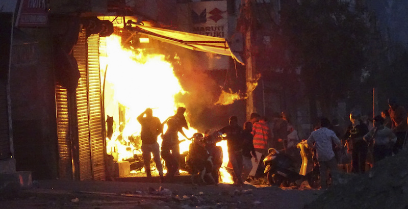 Un negozio incendiato a Delhi (AP Photo)