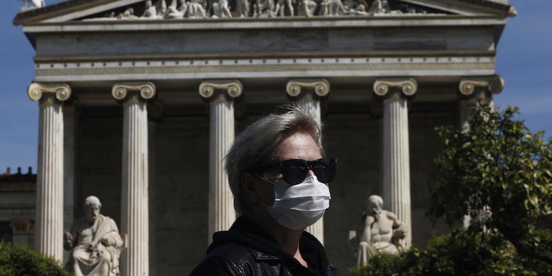 

Una donna indossa una mascherina in centro ad Atene (EPA/YANNIS KOLESIDIS)