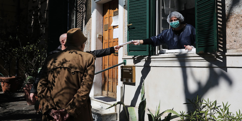 La segretaria di un medico di famiglia a Roma consegna una ricetta a un paziente. (Marco Di Lauro/Getty Images)