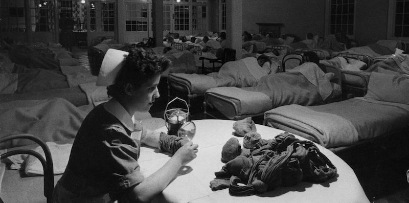 Una infermiera rammenda calzini nel dormitorio di un ospedale, nel 1956. (Auerbach/Getty Images)