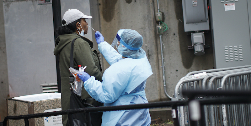 Un operatore sanitario effettua un tampone per il coronavirus su un paziente fuori dal Brooklyn Hospital Center di New York, Stati Uniti (AP Photo/John Minchillo)