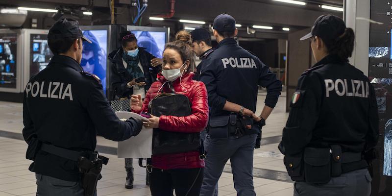 Poliziotti fanno dei controlli su chi usa la metropolitana di Milano, il 18 marzo 2020 (ANSA/Marco Ottico)