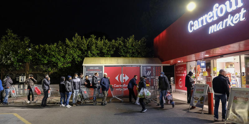Persone in fila nella notte fuori da un supermercato del quartiere Balduina, a Roma, il 10 marzo 2020 (ANSA/ALESSANDRO DI MEO)