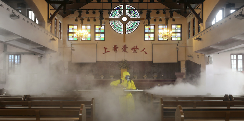 Un operatore sanitario disinfetta una chiesa cristiana a Wuhan (Chinatopix via AP)