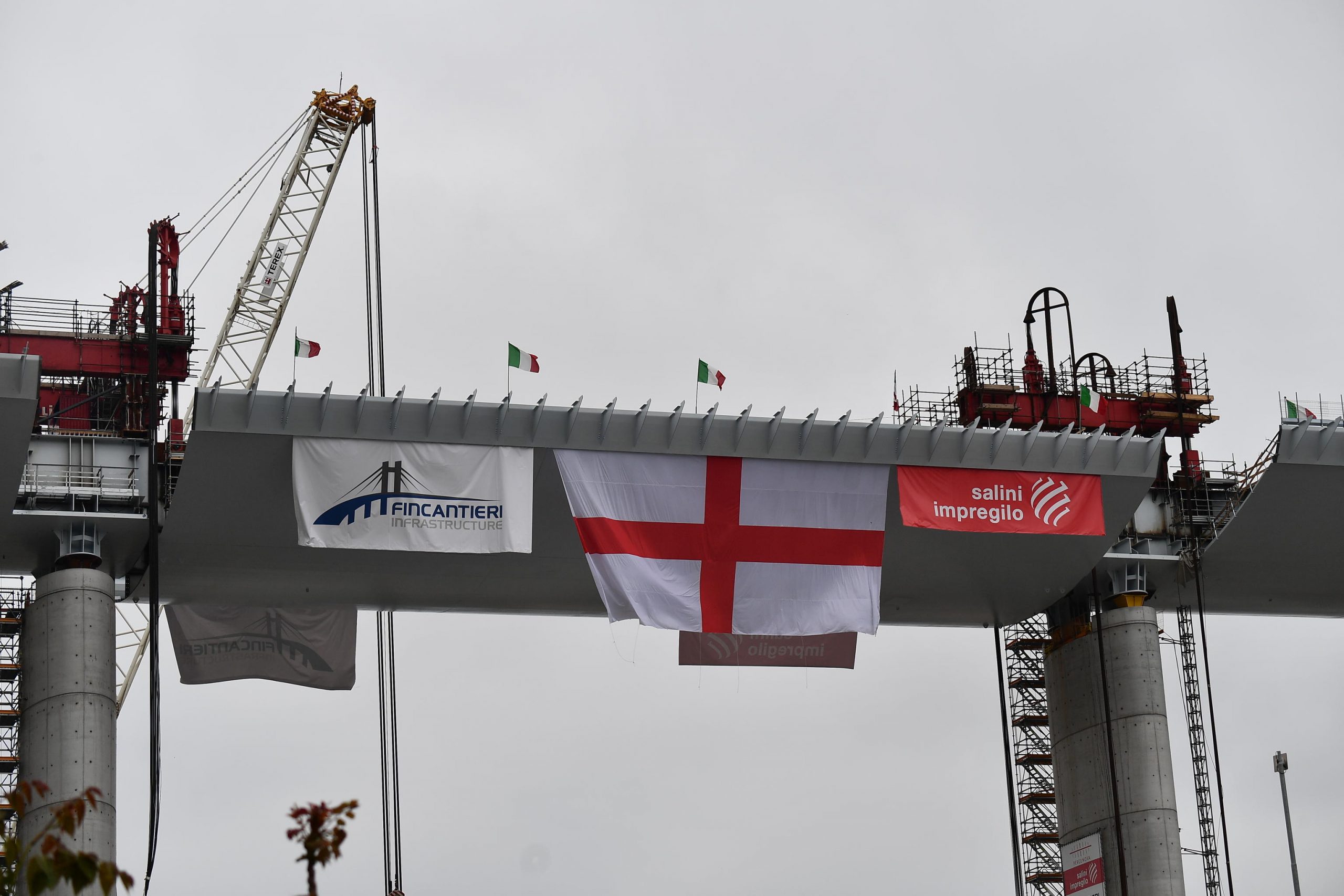 La croce di San Giorgio, la bandiera della città, appesa sull'ultima parte di impalcato del ponte di Genova, 28 aprile 2020. (ANSA/LUCA ZENNARO)