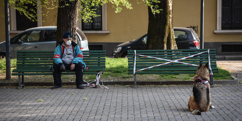 Un uomo e il suo cane nel parco Affori, a Milano, il 3 aprile 2020 (ANSA/MATTEO CORNER)