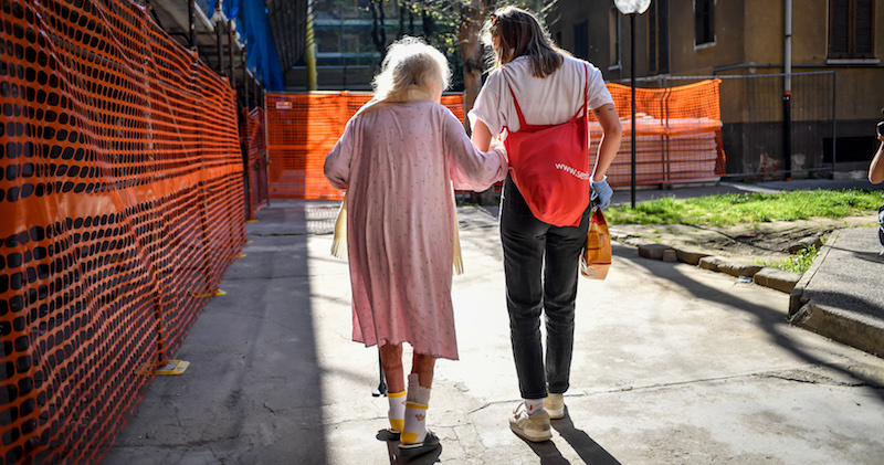 Una volontaria delle Brigate Volontarie per l'Emergenza di Milano con una donna residente nelle case popolari di via Giambellino, il 9 aprile 2020 (Claudio Furlan - LaPresse)